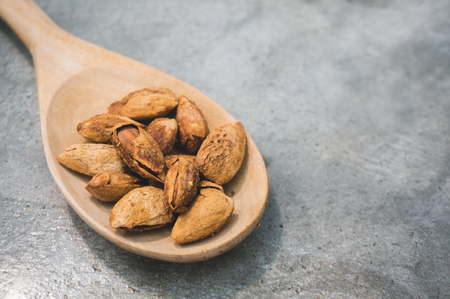 Almonds in wood spoonの写真素材