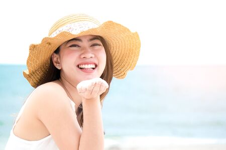 Asian woman with smile on the beach and blue sea feeling relax in holiday close upの写真素材