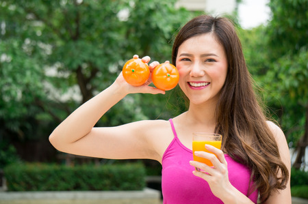 Asian healthy woman eat orange juice for health with smileの写真素材