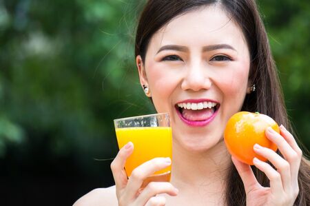 Asian beauty woman hold fruit and vegetable for healthy on grass with smileの写真素材