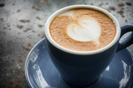 Latte coffee in blue cup with white heartの写真素材