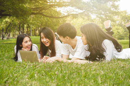 Asian student relax with friend in park for education conceptの写真素材
