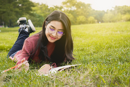 Asian student relax with friend in park for education conceptの写真素材