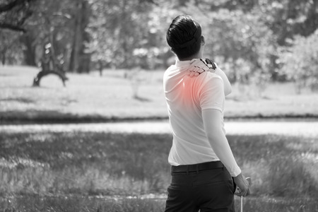 Sport man has back pain. Man rubbing his painful back close up.の写真素材