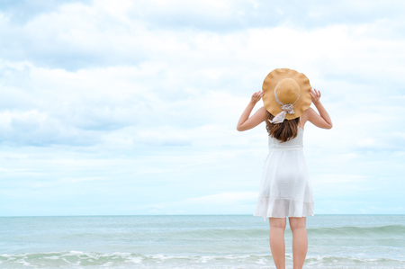 Asian woman relax on the beach in summer with sky and seaの写真素材