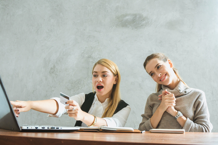 Woman and friend shopping online in sale season via websiteの写真素材