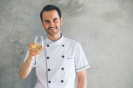 Chef holding wine glass to celebrateの写真素材