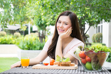 Asian healthy woman eat fresh vegetable for health in morningの写真素材