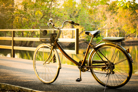 A bicycle / bike on bridge with sunlight and green tree in park outdoor for backgroundの写真素材