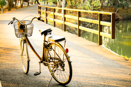 A bicycle / bike on bridge with sunlight and green tree in park outdoor for backgroundの写真素材