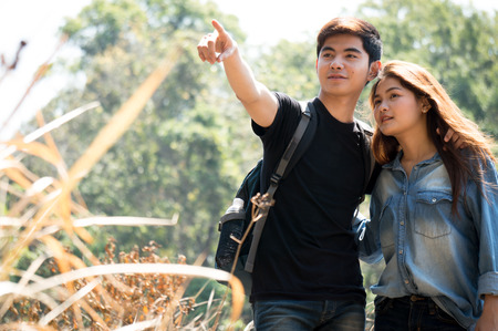 Asian travelers as couple pointing to target in autumn forestの写真素材