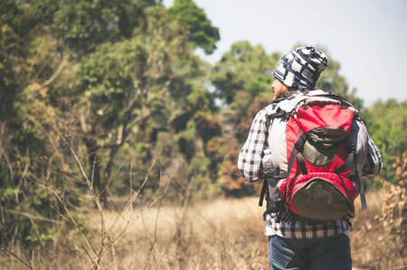 Traveler looking to map on the way in forestの写真素材