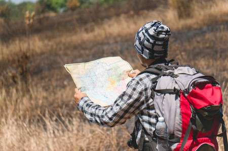Asian backpacker hold map in forestの写真素材
