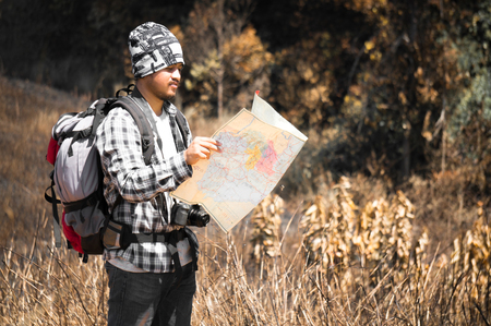 Traveler looking to map on the way in forestの写真素材