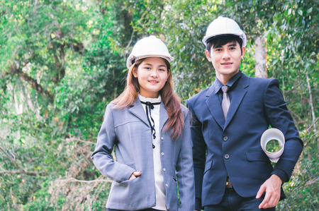 Engineer team holding blueprint for investment in forest backgroundの写真素材