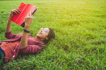 Asian woman with books in park for education conceptの写真素材