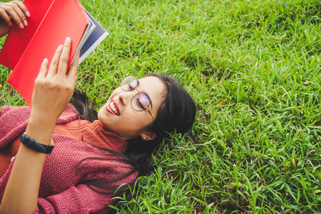 Asian woman with books in park for education conceptの写真素材
