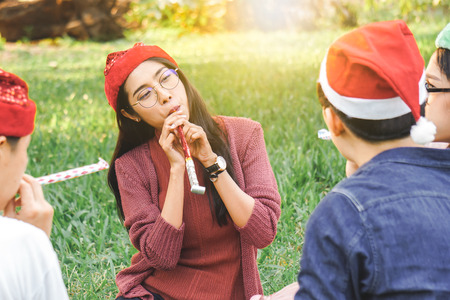 Asian woman and friend celebrate Christmas holiday in parkの写真素材