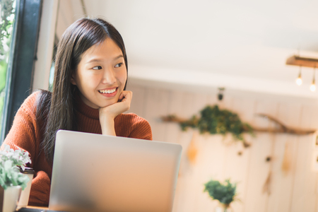 Asian woman working on labtop in coffee shopの写真素材