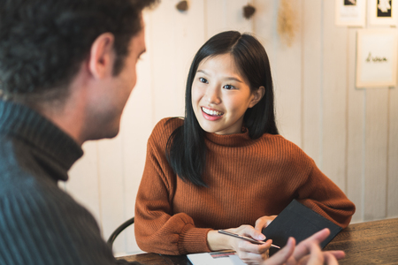 Asian woman discuss with customer in restaurantの写真素材