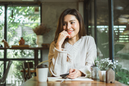 Asian woman working on labtop in coffee shopの写真素材
