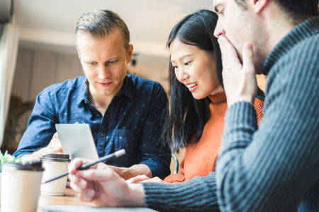 Businessman and partners discuss about business plan in cafÃ©の写真素材