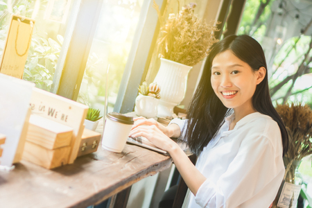 Asian woman working on labtop in coffee shopの写真素材