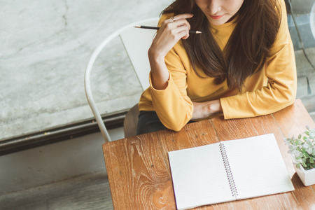 Asian woman working in cafÃ© and write on white paperの写真素材