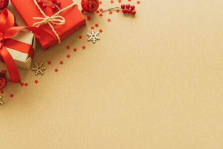 Christmas gifts on paper background with decoration, berries, star, snow flake and copy space. Flat lay, top viewの写真素材