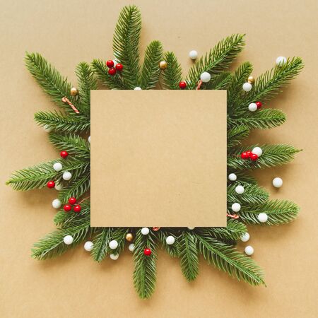 Christmas Flame made from red berries and green branches with snow on paper background. Flat lay, top view.の写真素材
