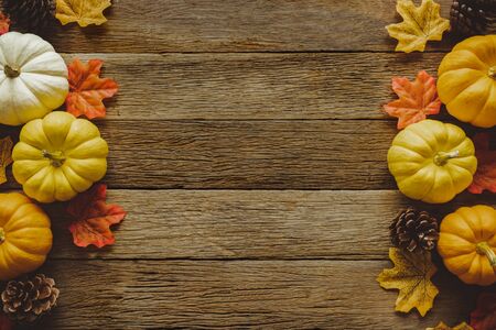 Autumn Thanksgiving day background from fallen leaves and fruits, pumpkin with vintage place setting on old wooden table. Thanksgiving day conceptの写真素材