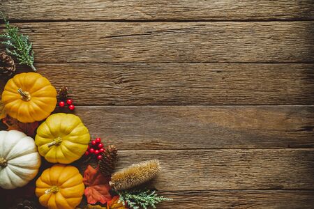 Autumn Thanksgiving day background from fallen leaves and fruits, pumpkin with vintage place setting on old wooden table. Thanksgiving day conceptの写真素材