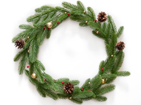 Christmas composition. Wreath made of christmas tree branches and pine cones with gold bubbles on white background. Flat lay, top view, copy spaceの写真素材