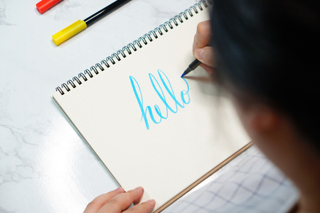 Female hands with pen writing on notebook