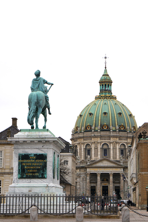 Copenhagen, Denmark - April 17, 2018: Frederik V of Denmark statue at Copenhagen's Amalienborg or Royal Palace courtyard with dome of Marble church (Frederik's Church) behind in Copenhagen, Denmarkのeditorial素材