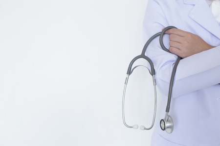 Female doctor holding a stethoscope in her hand with the white backgroundの写真素材