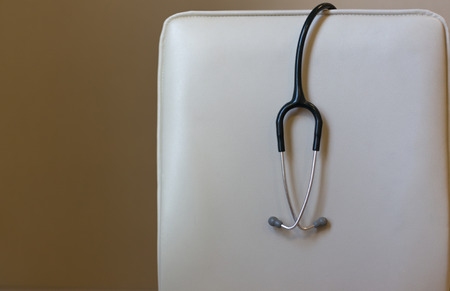 Stethoscope on the white doctor chair in the examination room of the hospitalの写真素材