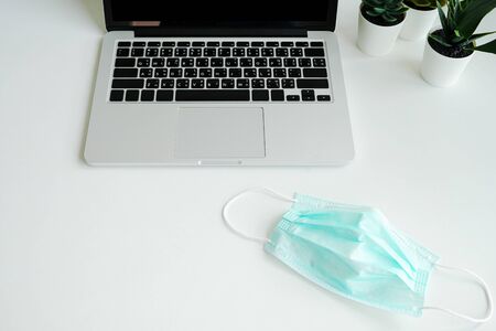 Work from home and . Medical mask with notebook laptop computer. Protection mask anti virus corona ncov for safety quarantineの写真素材
