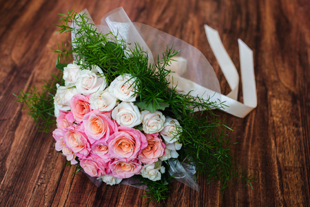 Wedding bouquet of roses lying on the floor. Flowers lie on a wooden tableの写真素材