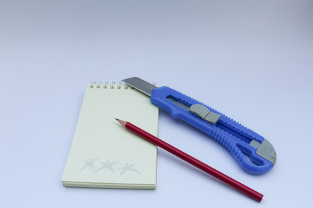pencil and Knife Sharpener on Note book isolated on white background