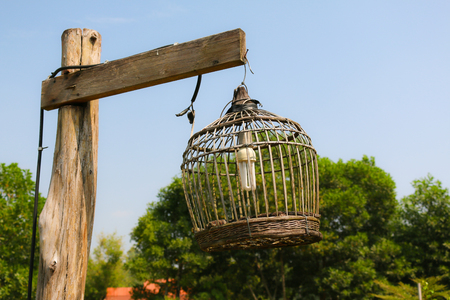 bird cage lamp on wooden postの写真素材