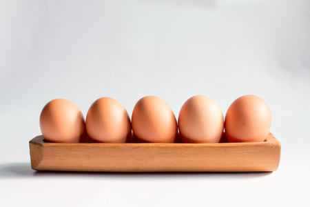 Egg in a wooden tray white background