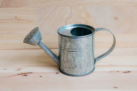 Watering Can miniature wooden backgroundの写真素材