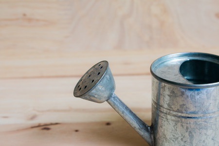 Watering Can miniature wooden backgroundの写真素材
