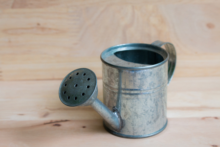 Watering Can miniature wooden backgroundの写真素材