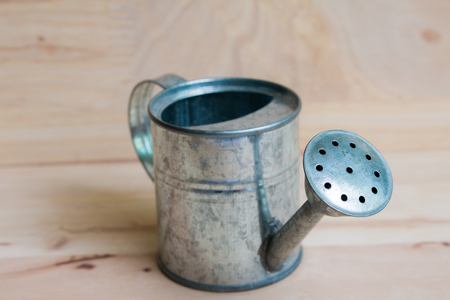Watering Can miniature wooden backgroundの写真素材