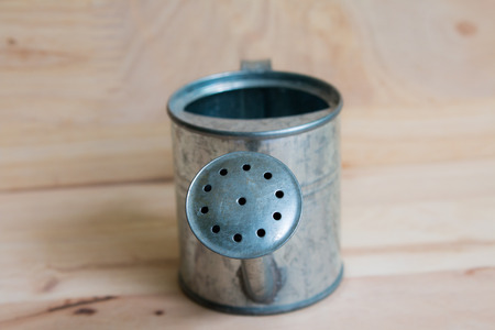 Watering Can miniature wooden backgroundの写真素材
