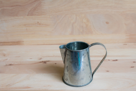 Watering Can miniature wooden backgroundの写真素材