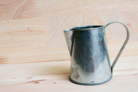 Watering Can miniature wooden backgroundの写真素材