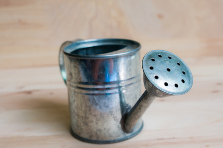 Watering Can miniature wooden backgroundの写真素材